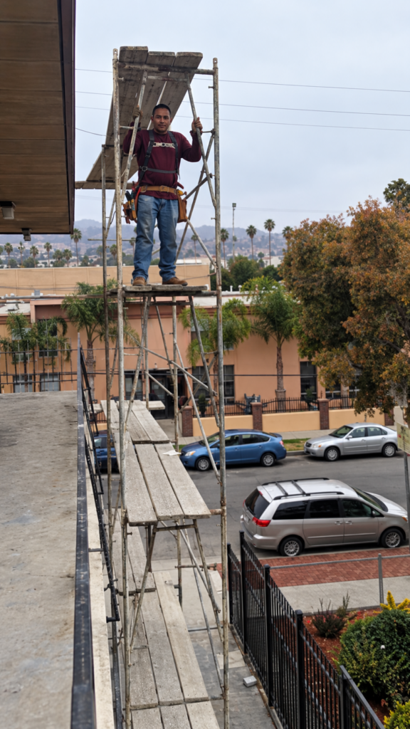 Plasterer working on an exterior wall from scaffolding