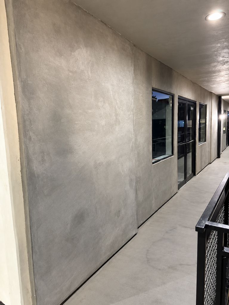 Custom textured wall finish beside a row of windows